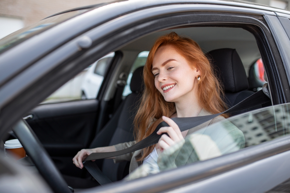 Young woman in a rental car with a student discount