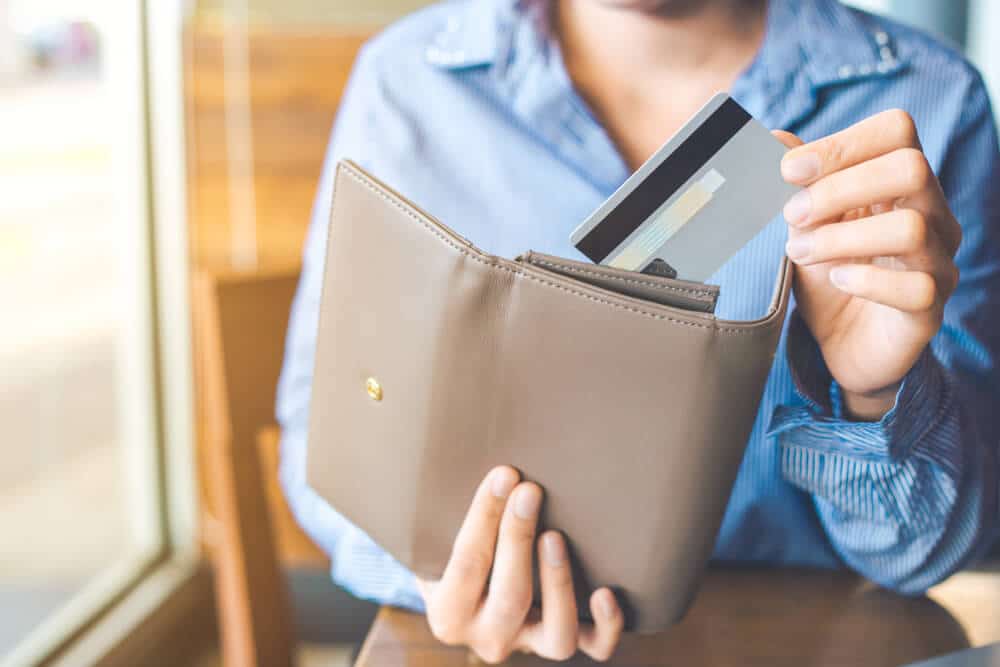 Person putting credit card in wallet