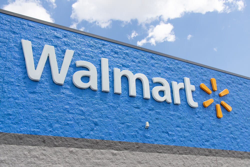 White and yellow logo sign on the outside of a Walmart store