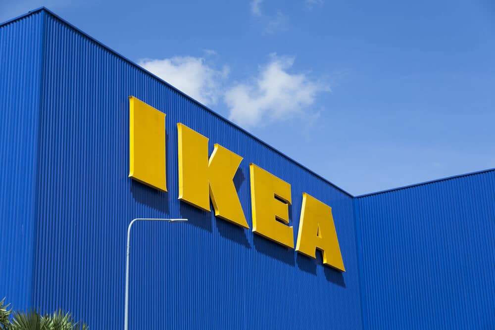 Yellow logo sign on the outside of a blue IKEA building