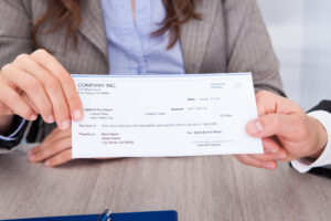 Woman and man holding a sample third-party check