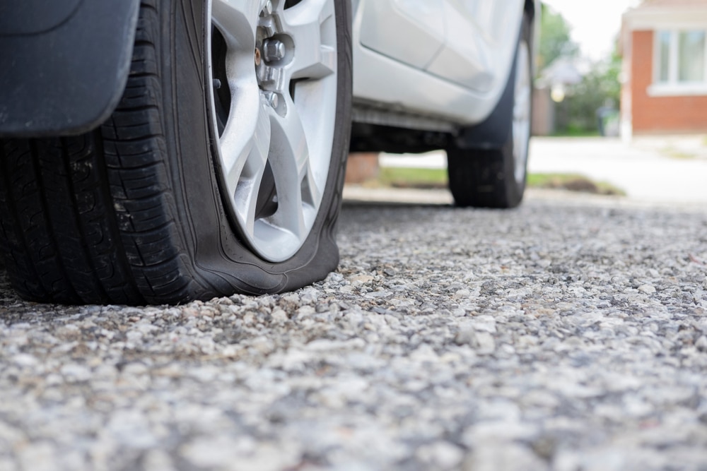 Close-up of a flat tire on a white car