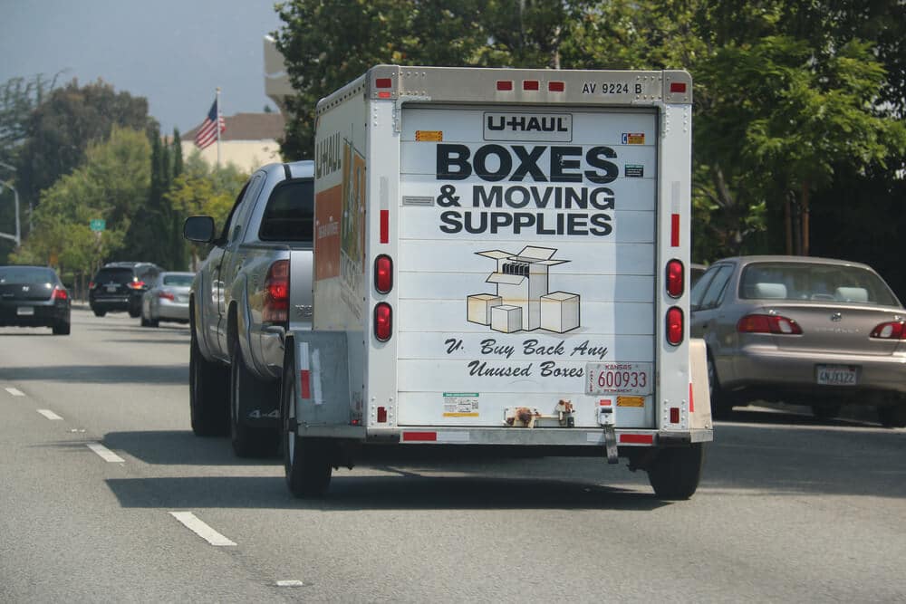 A U-Haul trailer being pulled by a truck
