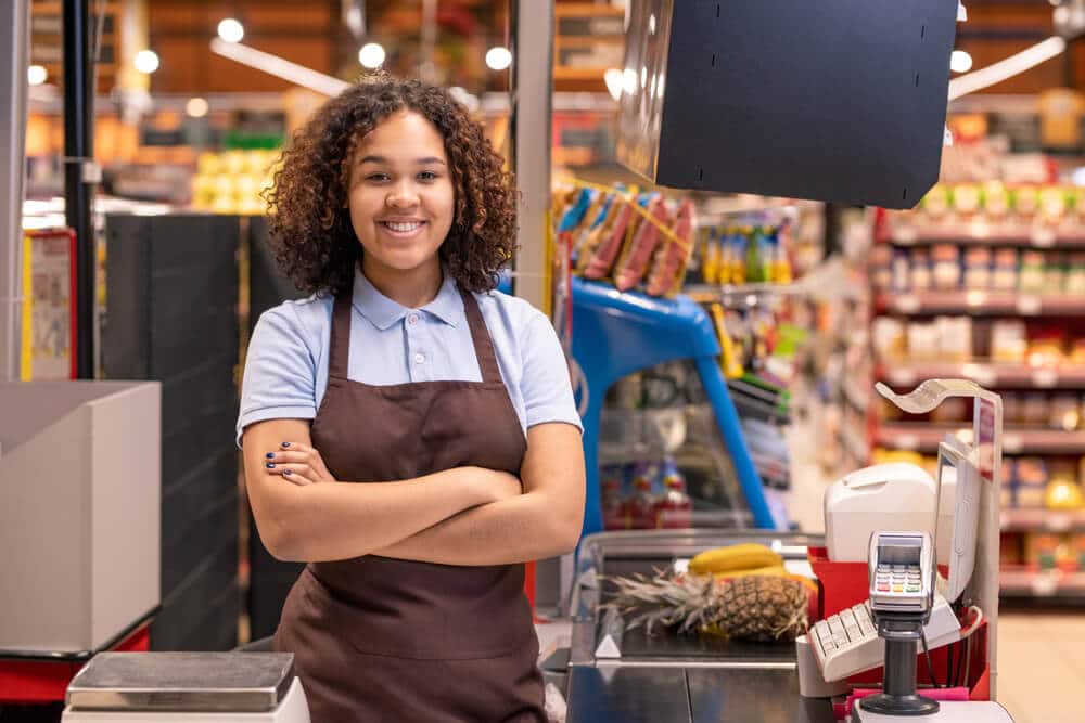 teen girl working as a cashier at a grocery store