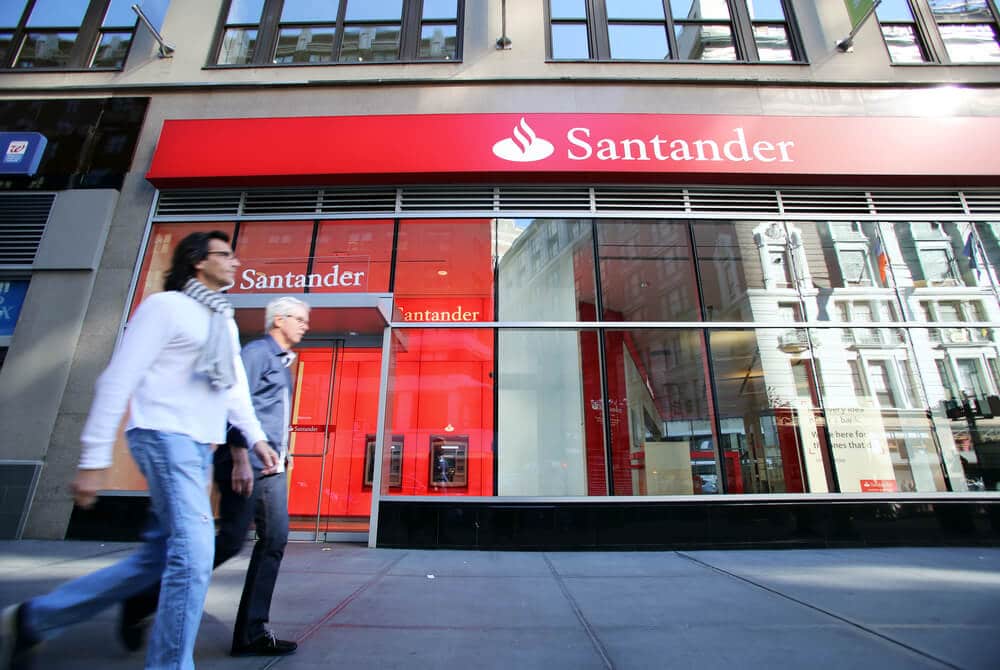 people walking past a Santander bank branch
