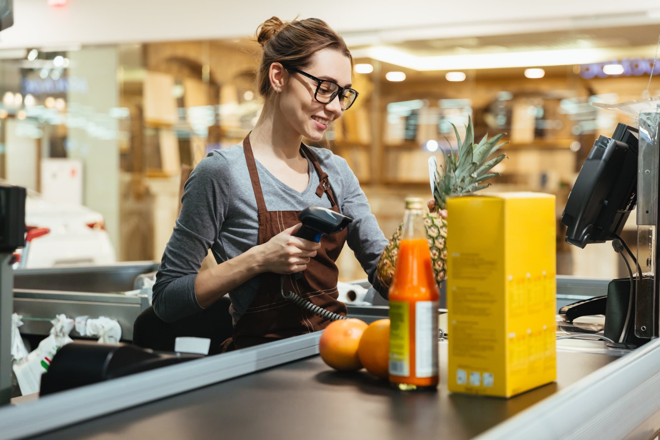 teenager working at grocery store checkout